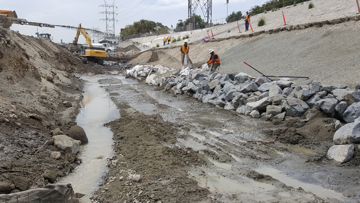 Bedding material is being placed on the embankment